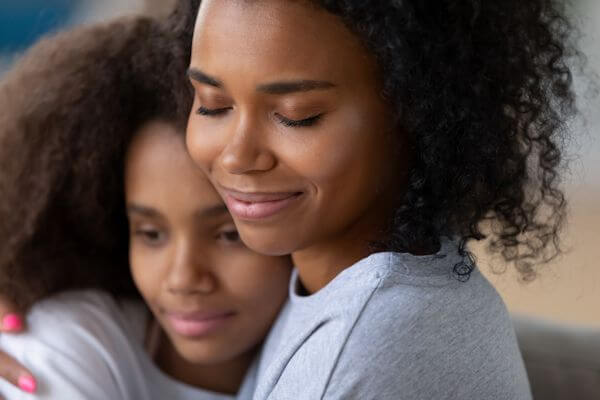 Mom hugging her teenage daughter